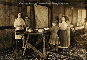 Young Oyster Pickers working through the lunch period at Peerless Oyster Co., Bay St Louis, Mississippi, USA (1911)